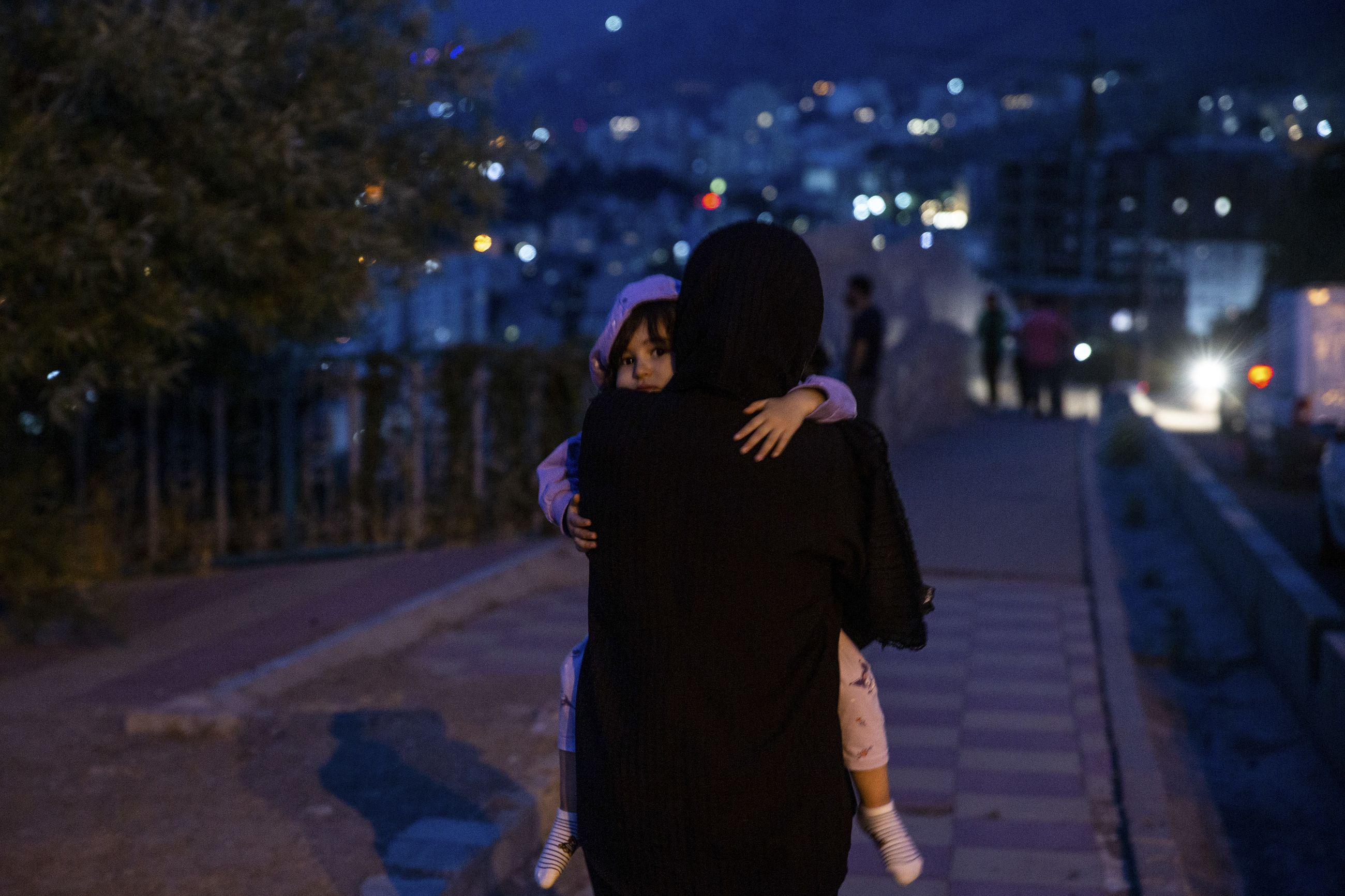 : En person bærer et barn i Teherans gater tidlig fredag morgen, etter å ha hørt lyden av israelske angrep.