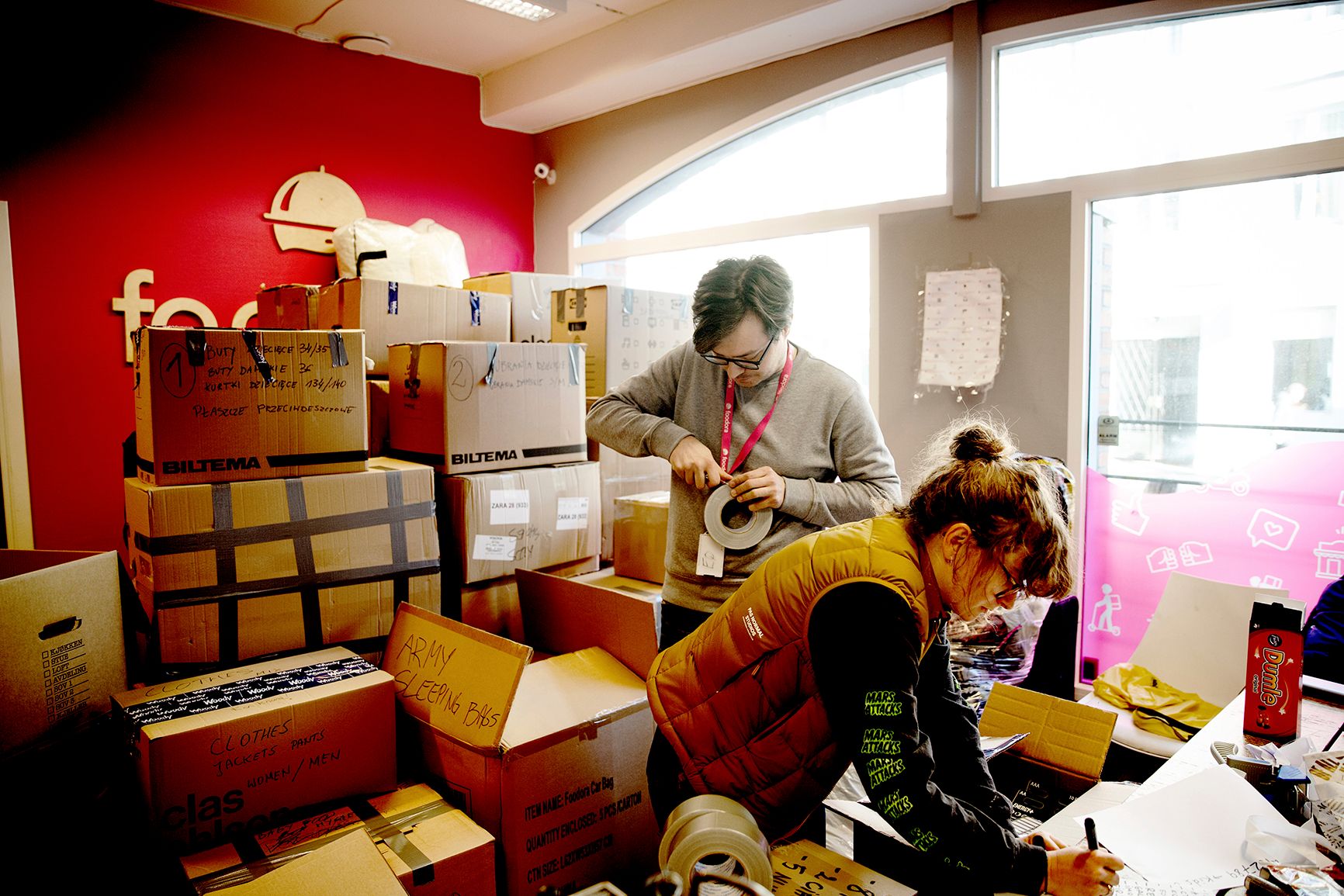 Krzysztof Szymanski pakker esker som skal til Ukraina sammen med Anatoliy Tanaschuk og Stefaniya Gutovska. Her er de i Foodoras lokaler i Oslo. Foto: Hanne Marie Lenth Solbø