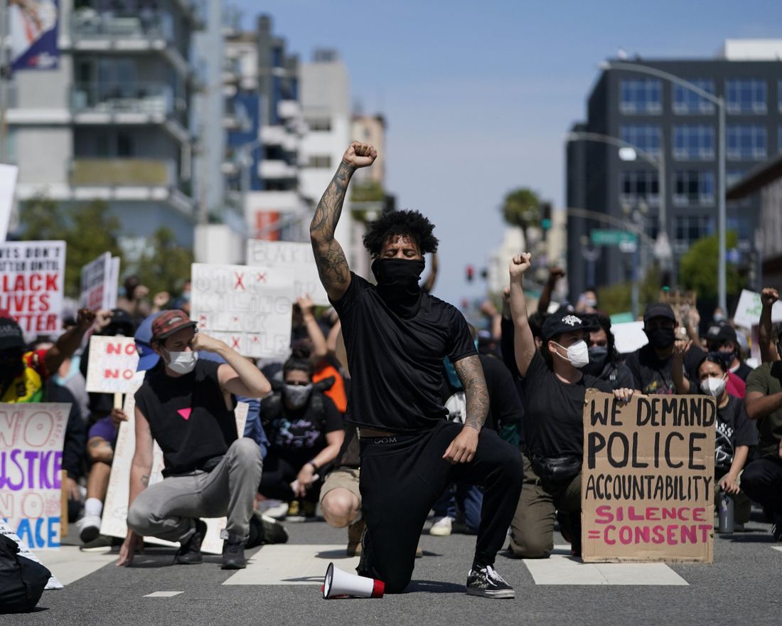 Demonstrators kneel in a moment of silence outside the Long Beach Police Department on Sunday, May 31, 2020, in Long Beach during a protest over the death of George Floyd. Protests were held in U.S. cities over the death of Floyd, a black man who died after being restrained by Minneapolis police officers on May 25. (AP Photo/Ashley Landis)