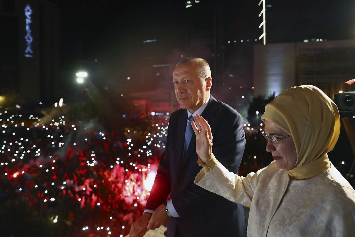Turkey's President Recep Tayyip Erdogan, accompanied by his wife Emine waves to supporters of his ruling Justice and Development Party (AKP) in Ankara, Turkey, early Monday, June 25, 2018. Erdogan won Turkey's landmark election Sunday, the country's electoral commission said, ushering in a new system granting the president sweeping new powers which critics say will cement what they call a one-man rule (Presidency Press Service via AP, Pool)