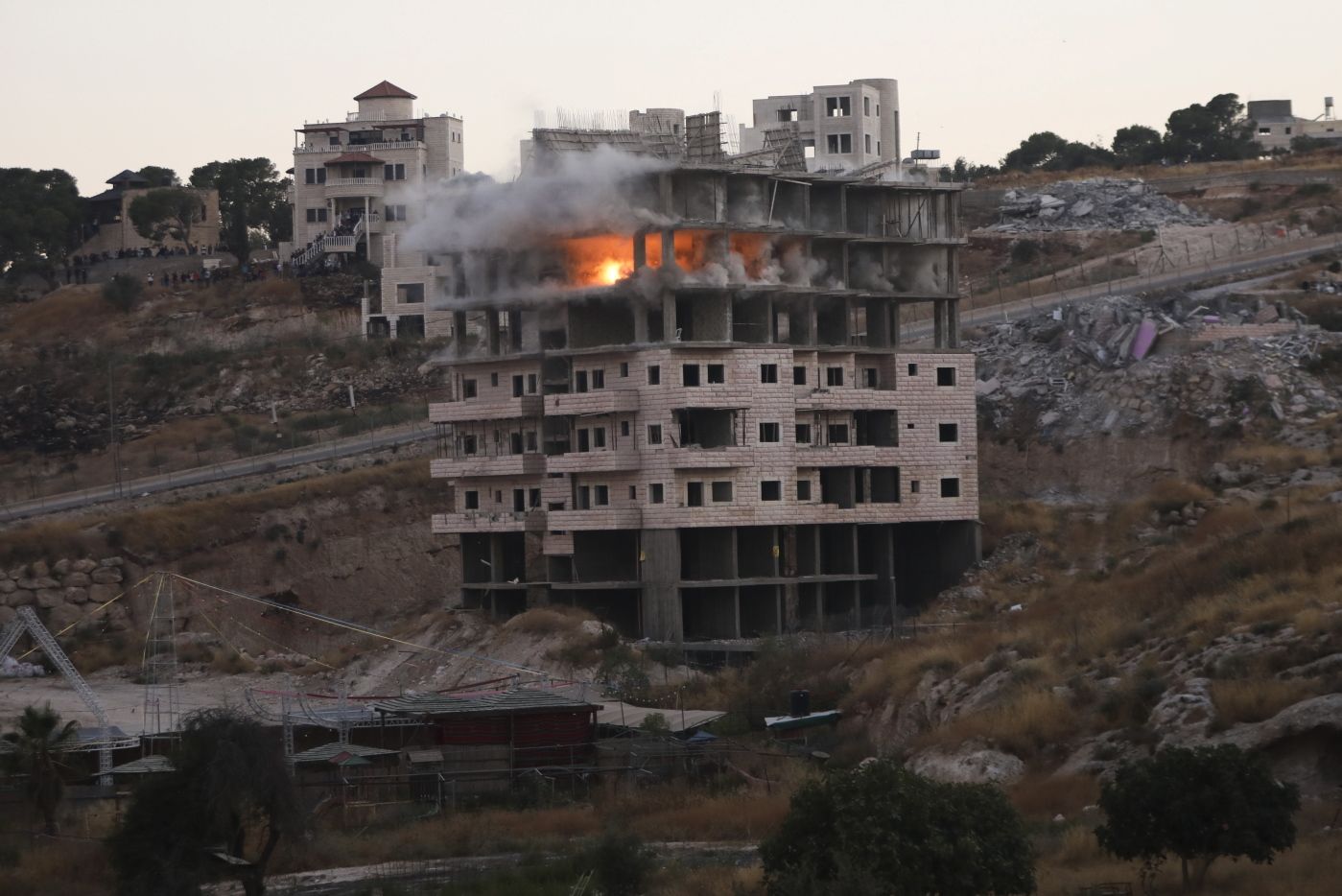 Israeli forces blow up a building in a Palestinian village of Sur Baher, east Jerusalem, Monday, July 22, 2019. Israeli work crews have begun demolishing dozens of Palestinian homes in an east Jerusalem neighborhood. Monday's demolitions cap a years-long legal battle over the buildings, which straddle the city and the occupied West Bank. (AP Photo/Mahmoud Illean)