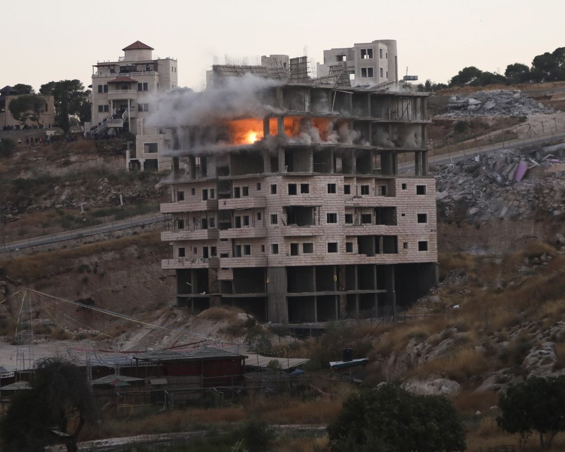 Israeli forces blow up a building in a Palestinian village of Sur Baher, east Jerusalem, Monday, July 22, 2019. Israeli work crews have begun demolishing dozens of Palestinian homes in an east Jerusalem neighborhood. Monday's demolitions cap a years-long legal battle over the buildings, which straddle the city and the occupied West Bank. (AP Photo/Mahmoud Illean)