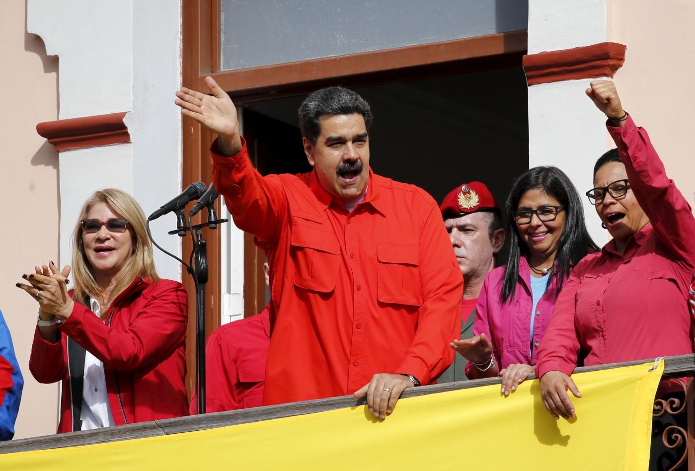 Venezuela's President Nicolas Maduro, center, and first lady Cilia Flores, left, interact with supporters from a balcony at Miraflores presidential palace during a rally in Caracas, Venezuela, Wednesday, Jan. 23, 2019. At a competing rally, opposition leader Juan Guaido declared himself interim president until new elections can be held, to which Maduro responded by cutting off diplomatic relations with the United States and said American diplomats had 72 hours to leave the country. (AP Photo/Ariana Cubillos)