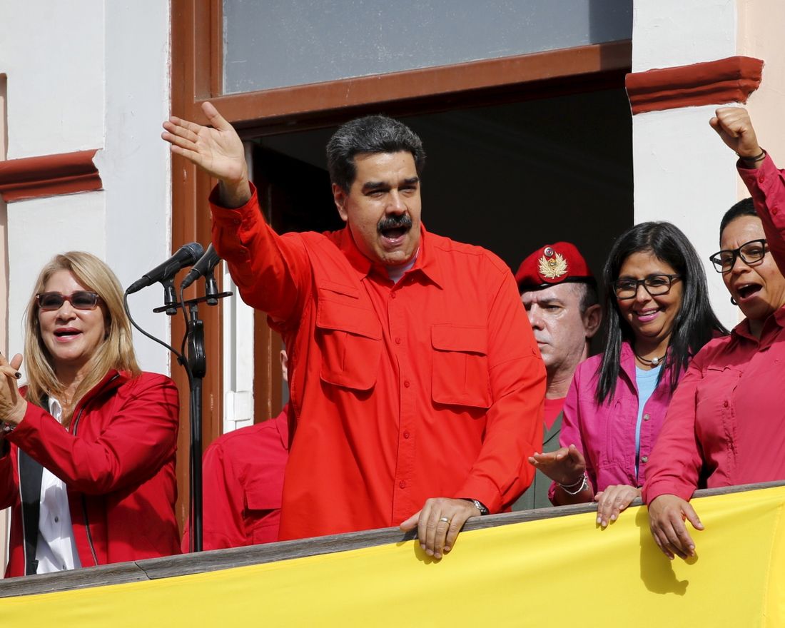 Venezuela's President Nicolas Maduro, center, and first lady Cilia Flores, left, interact with supporters from a balcony at Miraflores presidential palace during a rally in Caracas, Venezuela, Wednesday, Jan. 23, 2019. At a competing rally, opposition leader Juan Guaido declared himself interim president until new elections can be held, to which Maduro responded by cutting off diplomatic relations with the United States and said American diplomats had 72 hours to leave the country. (AP Photo/Ariana Cubillos)