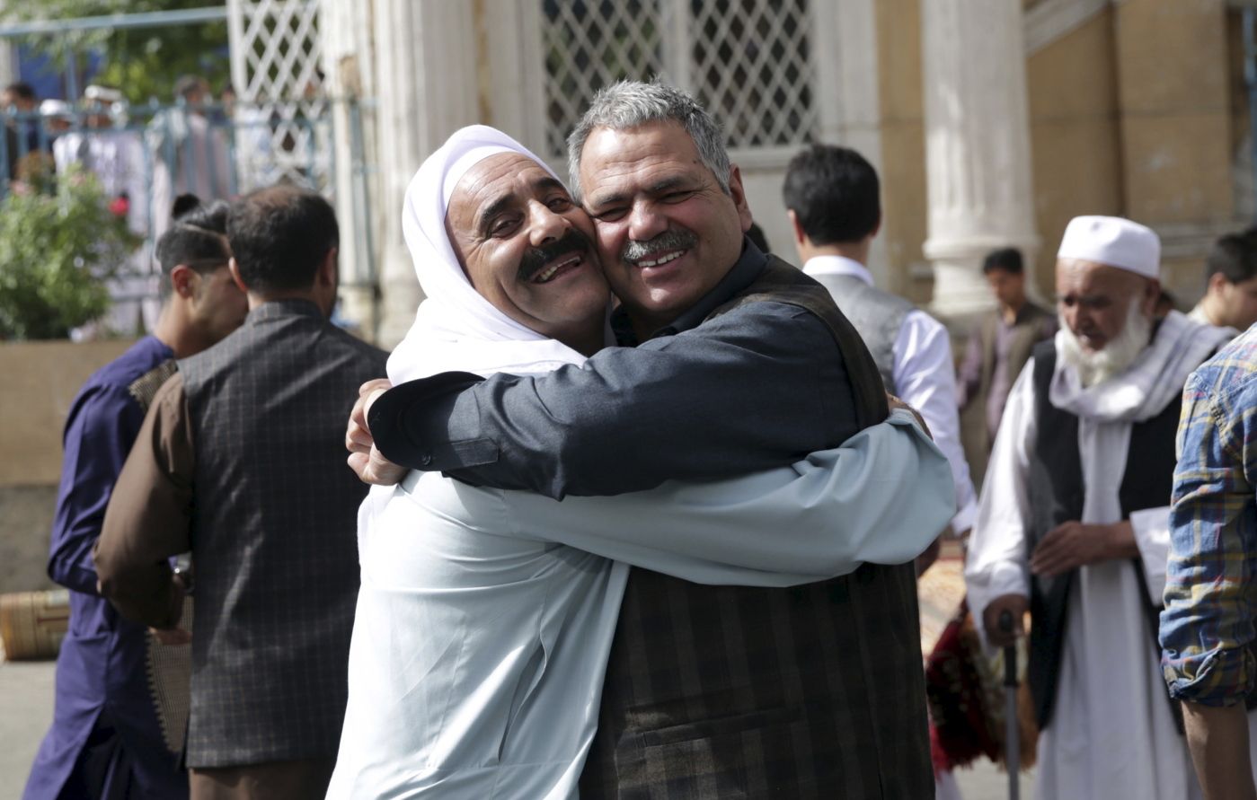 Men hug each other after Eid al-Fitr prayers outside of Shah-e-Dushamshera mosque in Kabul, Afghanistan, Friday, June 15, 2018. Taliban, an insurgent group who fight against NATO and Afghanistan's government, announced that they will start a 3-day ceasefire, starting in the first day of Eid al-Fitr. (AP Photo/Massoud Hossaini)
