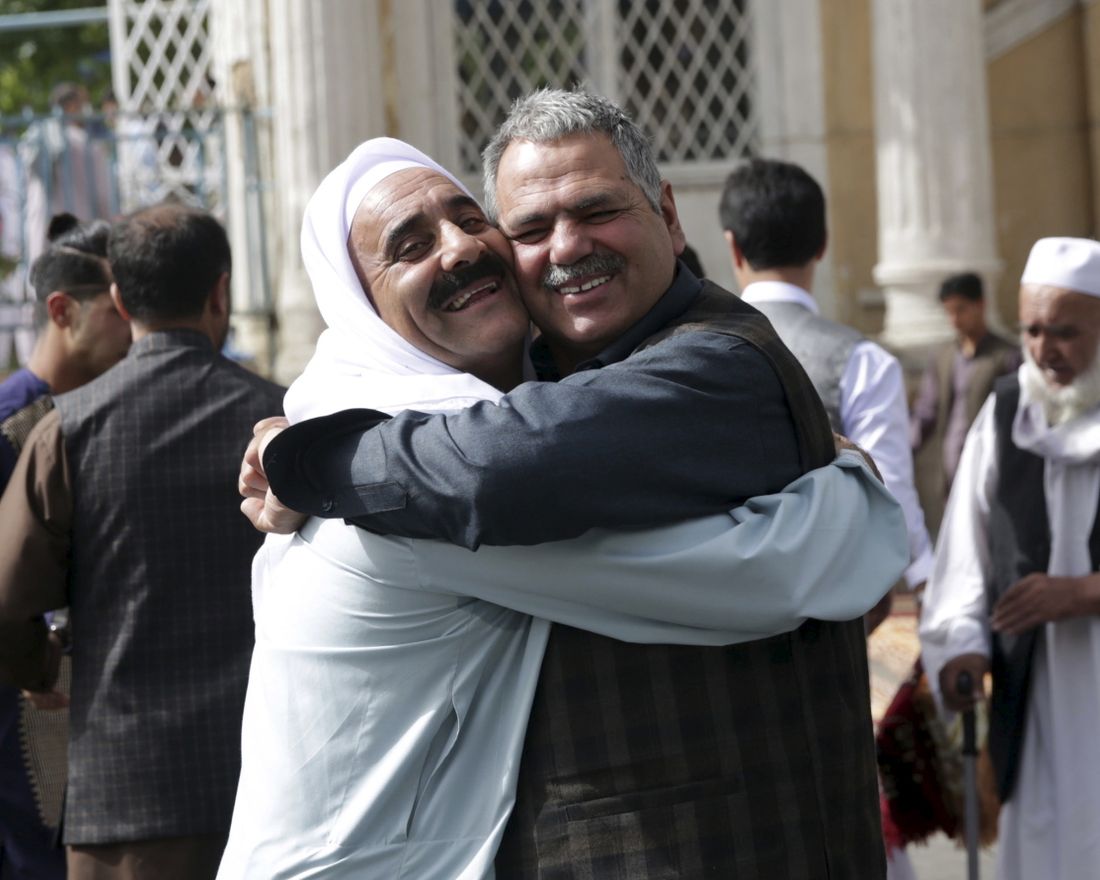 Men hug each other after Eid al-Fitr prayers outside of Shah-e-Dushamshera mosque in Kabul, Afghanistan, Friday, June 15, 2018. Taliban, an insurgent group who fight against NATO and Afghanistan's government, announced that they will start a 3-day ceasefire, starting in the first day of Eid al-Fitr. (AP Photo/Massoud Hossaini)