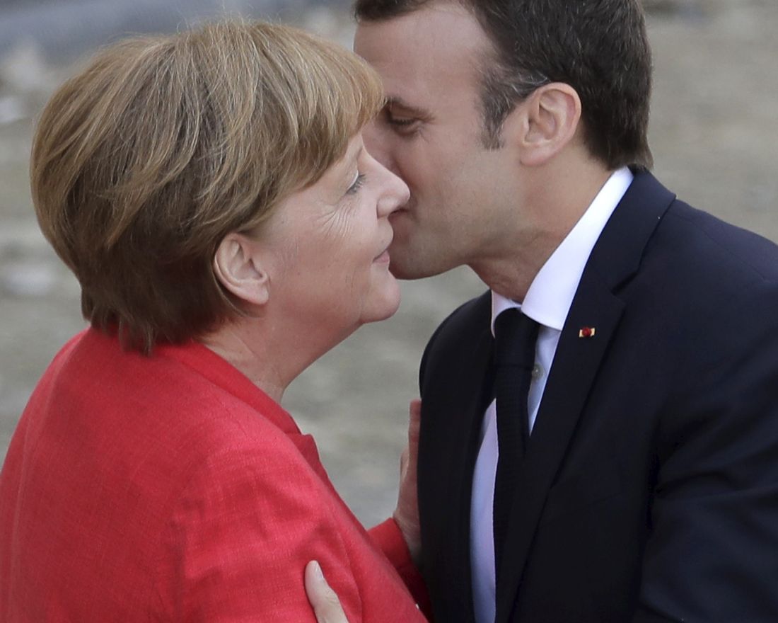 French President Emmanuel Macron, right, is welcomed by German Chancellor Angela Merkel before they visit the reconstruction site of the Berlin Palace in Berlin, Germany, Thursday, April 19, 2018. (AP Photo/Markus Schreiber)