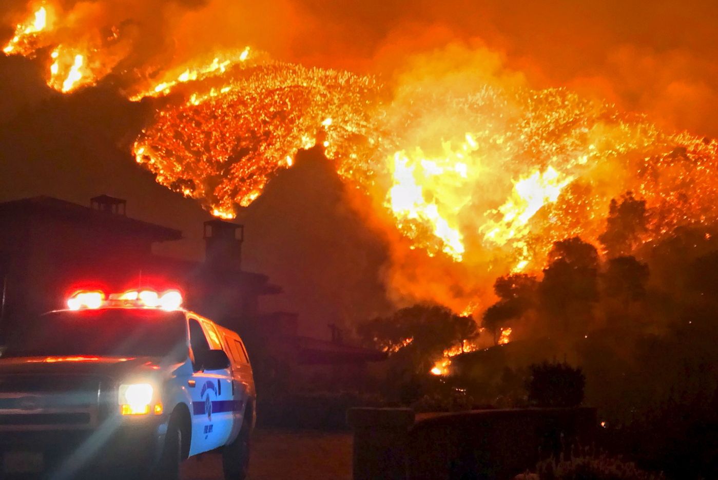 FILE - In this Dec. 12, 2017, file photo provided by the Santa Barbara County Fire Department, fire burns canyons and ridges above Bella Vista Drive near Romero Canyon as the fight to contain a wildfire continues in Montecito, Calif. An investigation has determined that one of the largest and most destructive fires in California history was sparked by power lines coming into contact during high winds. The Ventura County Fire Department says Wednesday that the contact ignited dry brush on Dec. 4, 2017 and eventually blackened more than 440 square miles (1,139 square kilometers). The Thomas fire destroyed more than a thousand structures in Ventura and Santa Barbara counties and resulted in the deaths of two people. (Mike Eliason/Santa Barbara County Fire Department via AP, File)