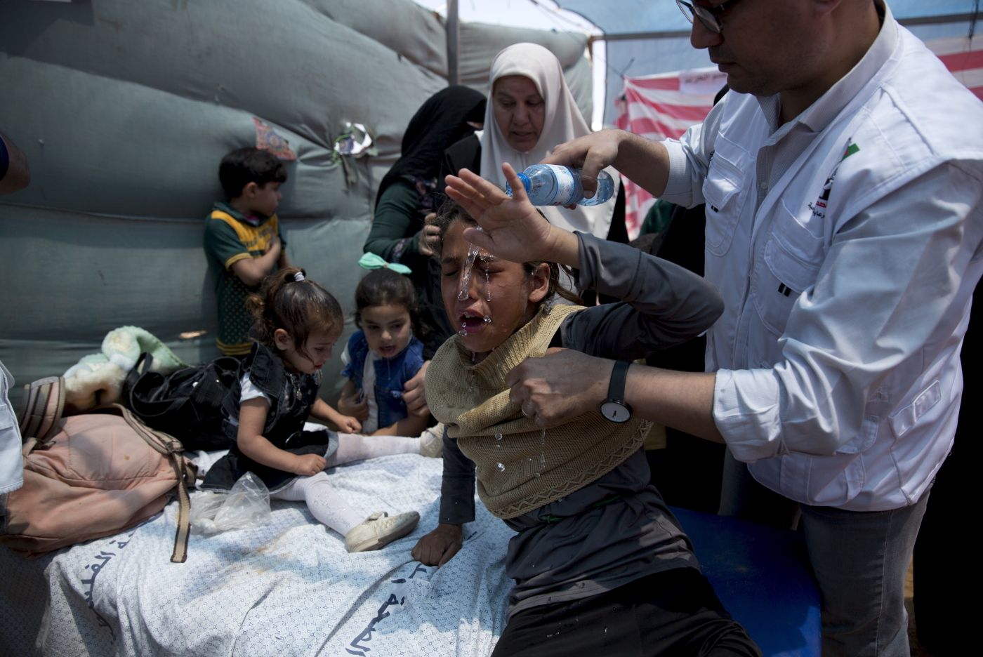 Medics treat Palestinian children suffering from teargas inhalation during a protest near Beit Lahiya, Gaza Strip, Monday, May 14, 2018. Israeli soldiers shot and killed dozens of Palestinians during mass protests along the Gaza border on Monday. It was the deadliest day there since a devastating 2014 cross-border war and cast a pall over Israel's festive inauguration of the new U.S. Embassy in contested Jerusalem. (AP Photo/Dusan Vranic)