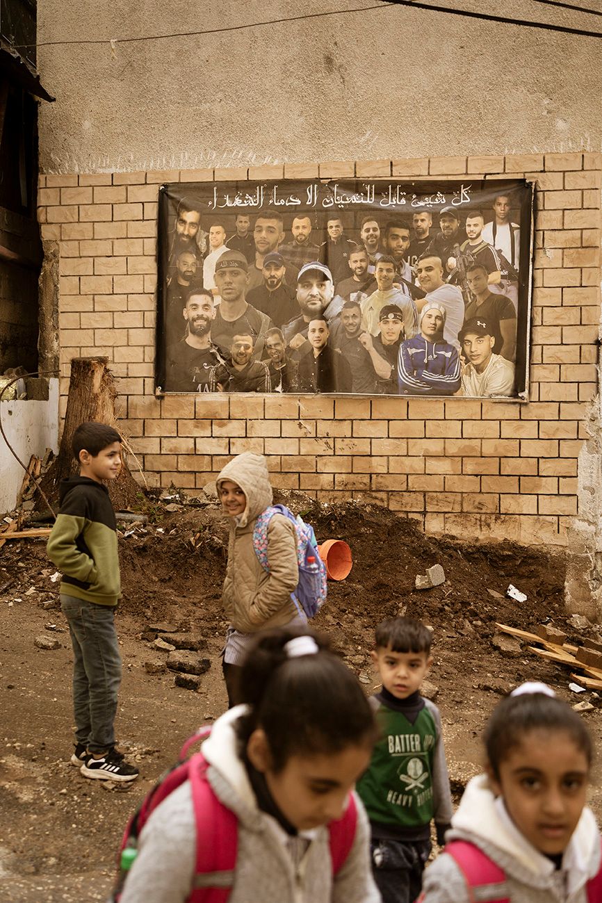 Tulkarem, Vestbredden, 11. januar Skolebarn er på vei hjem, i en by der det ikke er mange alternativer å velge mellom hva gjelder veivalg i livet. Her preges barndommen av israelske droner som hamrer byen fra luftet og bakkestyrker fra IDF er stadig inne i byen. I bakgrunnen henger en plakat med bilder av dem som har mistet livet i motstandskampen. «Alt kan bli glemt, bortsett fra martyrenes blod», lyder teksten. Foto: Christopher Olssøn