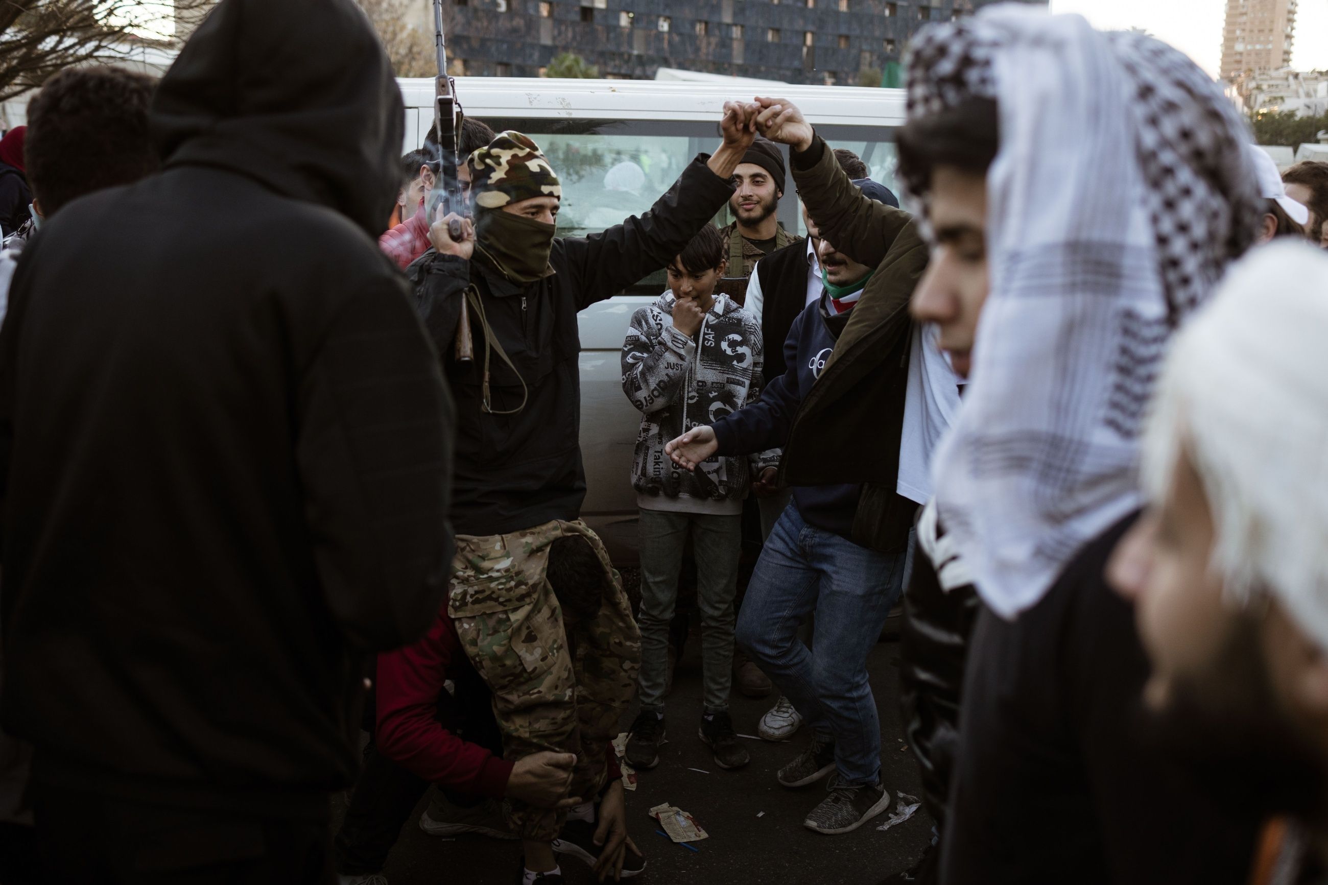 Krigerdans: En kriger fra militsgruppa HTS danser med sivile syrere i sentrum av Damaskus.