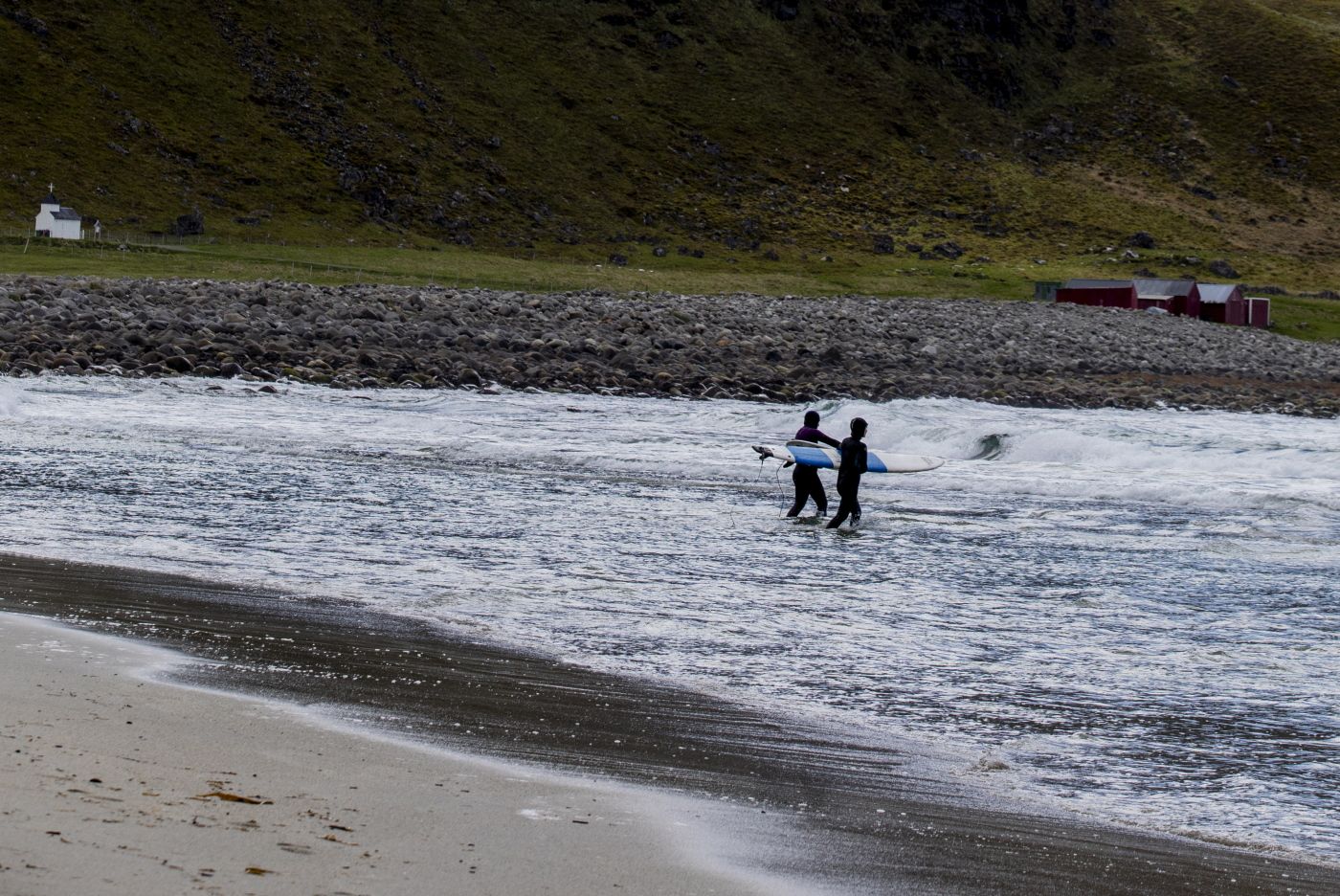 Hvordan jobbes det med stedsutvikling på steder som sliter med fraflytting og/eller masseturisme? Vi ta utgangspunkt i Røst, Henningsvær, Ramberg og Unstad, i Lofoten. 
  
 Bildet: Unstad i Vestvågøy kommune er stortsett fraflyttet. Nå bor det to geitebønder her. Stedet er likevel hyppig besøkt av turister, på grunn av den fine stranda, et ypperlig sted for surfere. Her er Unstad Arctic Surf etablert. Denne juniformiddagen er det en liten gruppe svenske jenter her, de er nybegynnere og noen av dem tar selve jomfrusurfen her ute, det er seks grader i lufta og knapt nok det i vannet. Den som aldri har vært på Unstad kan ikke forstå hvordan det er å kjøre gjennom tunellen, hvordan naturen åpenbarer seg, havet, de bratte åssidene som en beskyttende livmor over den brede, frodige dalen der sauer slumrer i det knallgrønne gresset. 
  
 Foto: Tom Henning Bratlie