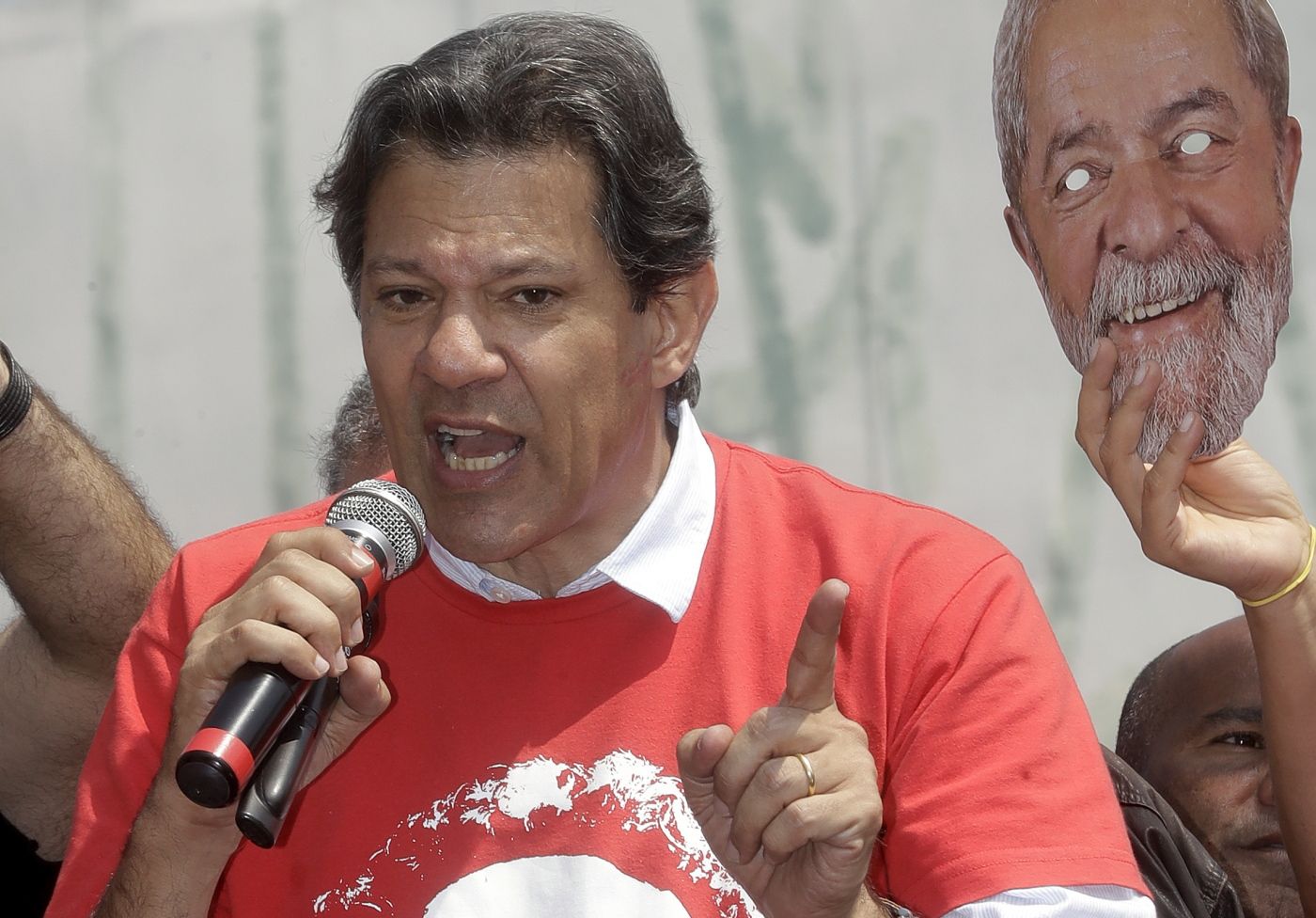Brazil's presidential candidate for the Workers Party Fernando Haddad speaks to supporters 
 during a campaign rally in Carapicuiba, the greater Sao Paulo area, Brazil, Thursday, Sept. 13, 2018. At right is a mask of jailed, former president Luiz Inacio Lula da Silva, who Haddad replaces as the party's candidate ahead of Oct. 7 elections. (AP Photo/Andre Penner)
