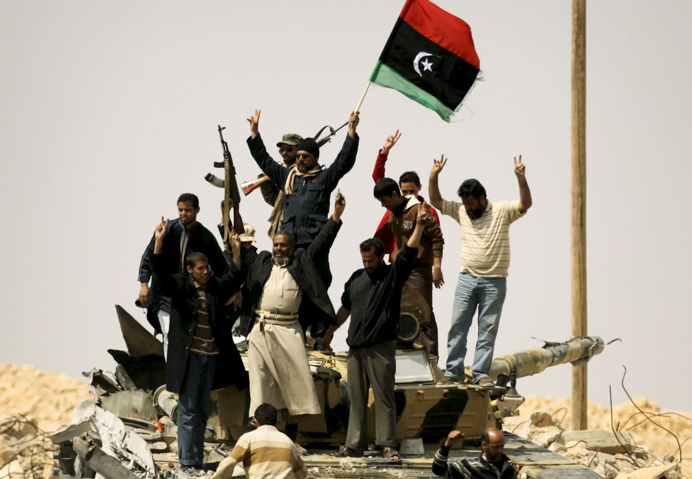 TOPSHOTS 
 Libyan rebels celebrate on a pro-Kadhafi forces destroyed tank as they enter the strategic oil town of Ajdabiya after defensive positions previously held by loyalists stood deserted following Western-led air strikes on March 26, 2011.    AFP PHOTO/ PATRICK BAZ