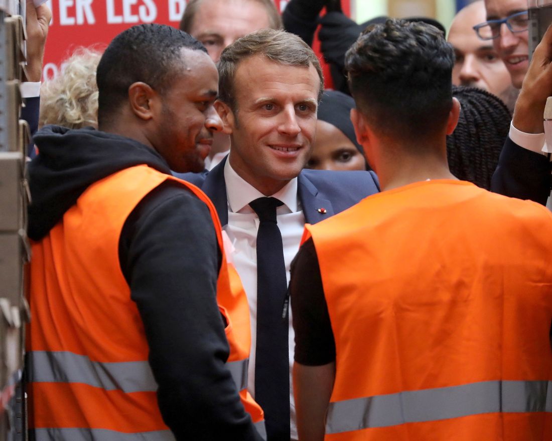 In this photo taken on Tuesday Sept. 10, 2019 French President Emmanuel Macron listens to warehouse workers in Bonneuil-sur-Marne, southwest of Paris. French President Emmanuel Macron was a world away from the glamor of hosting world leaders at a G-7 summit a few weeks earlier. This time, those he was trying to win over weren't President Donald Trump and other heads of states in the luxurious seaside resort of Biarritz, but workers struggling to make ends meet. (Ludovic Marin, Pool via AP)