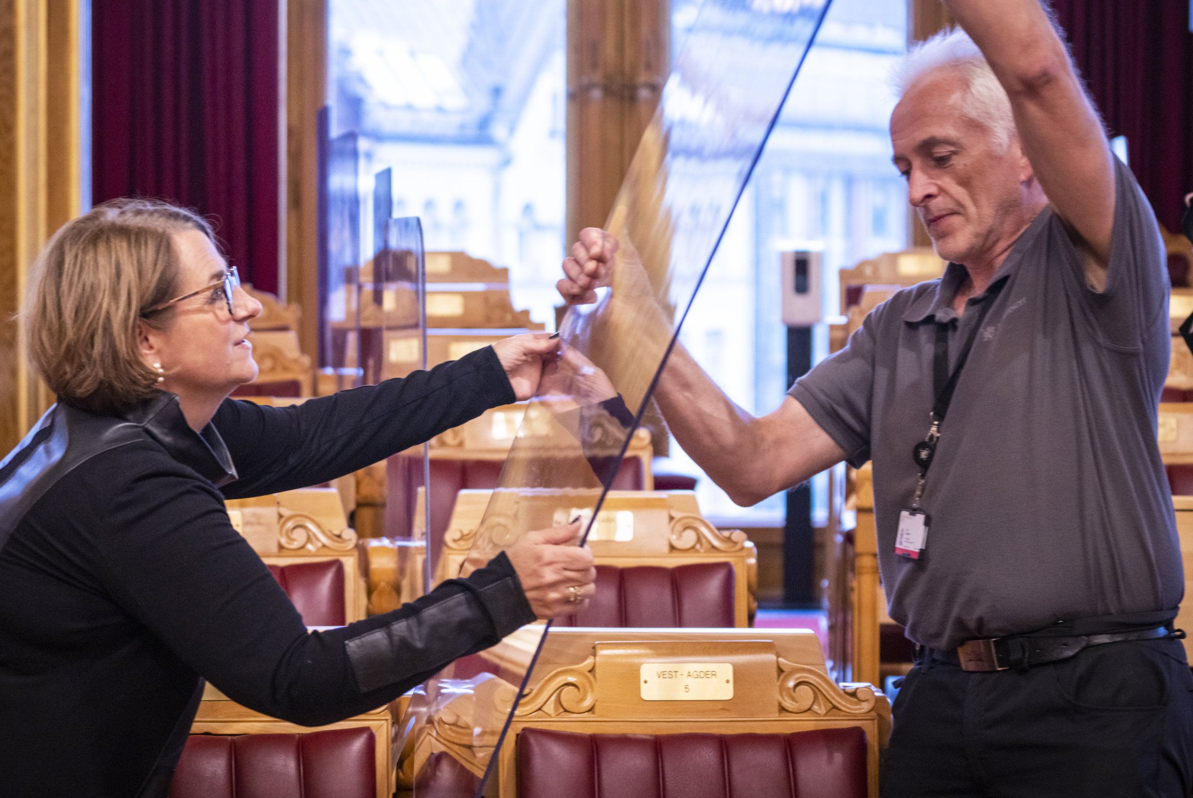 Oslo 20210930. 
 Stortingspresident Tone W. Trøen og driftstekniker Ivar Johansen fjerner pleksiglassene som ble satt opp i Stortingssalen i fjor vår i forbindelse med koronapandemien. 
 Foto: Ole Berg-Rusten / NTB