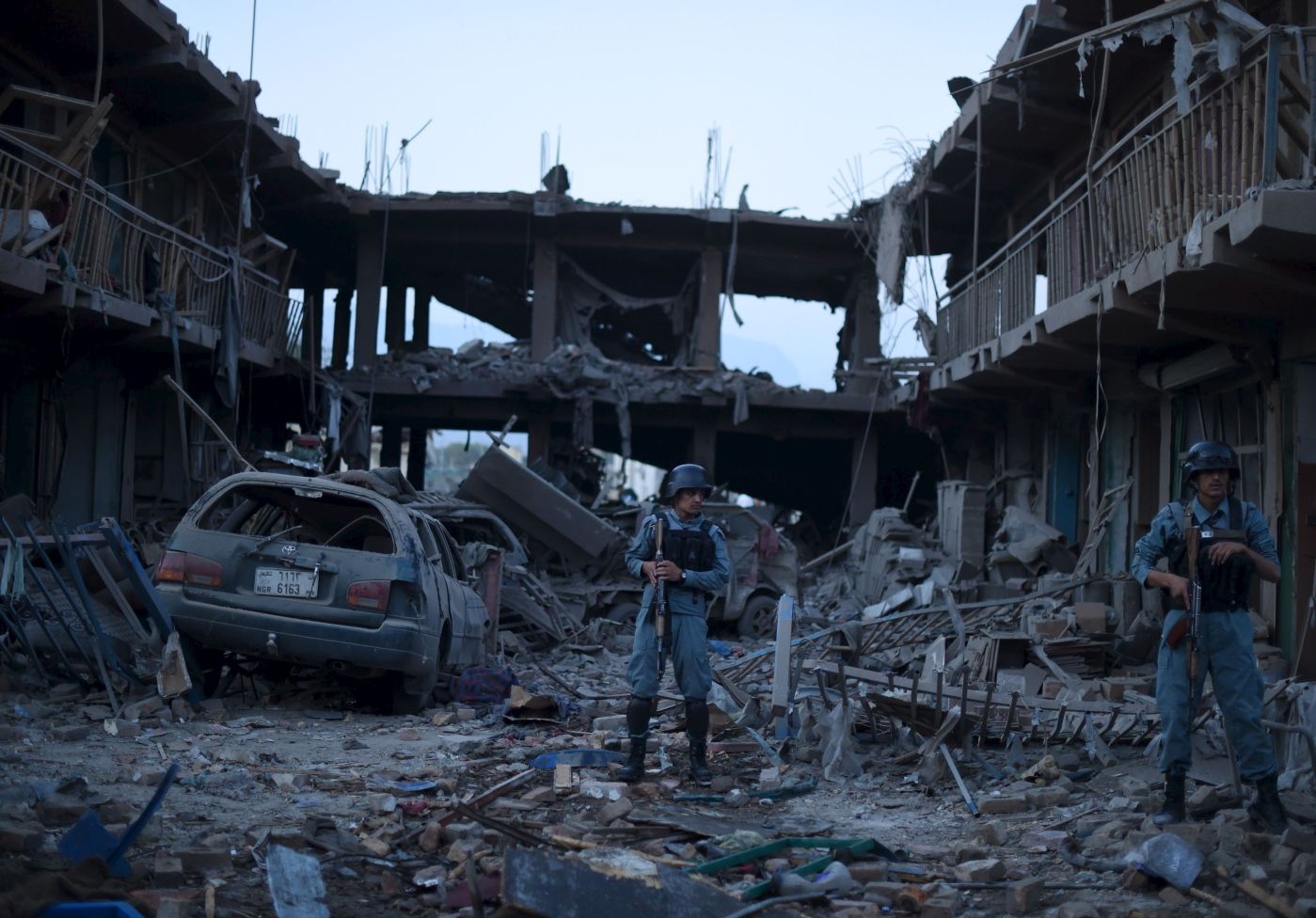 (FILES) This file photo taken on August 7, 2015 shows Afghan policemen standing guard at a market destroyed by a powerful truck bomb in Kabul, the first major attack in the Afghan capital since the announcement of Taliban leader Mullah Omar's death. 
 War crimes prosecutors said on November 3, 2017 they will ask the International Criminal Court's judges for permission to launch a full-blown probe into crimes committed in war-torn Afghanistan. During a lengthy probe first made public in 2007, the ICC has been looking at possible war crimes dating back to 2003 by the Taliban, Afghan government forces and international forces including US troops. 
 / AFP PHOTO / SHAH MARAI