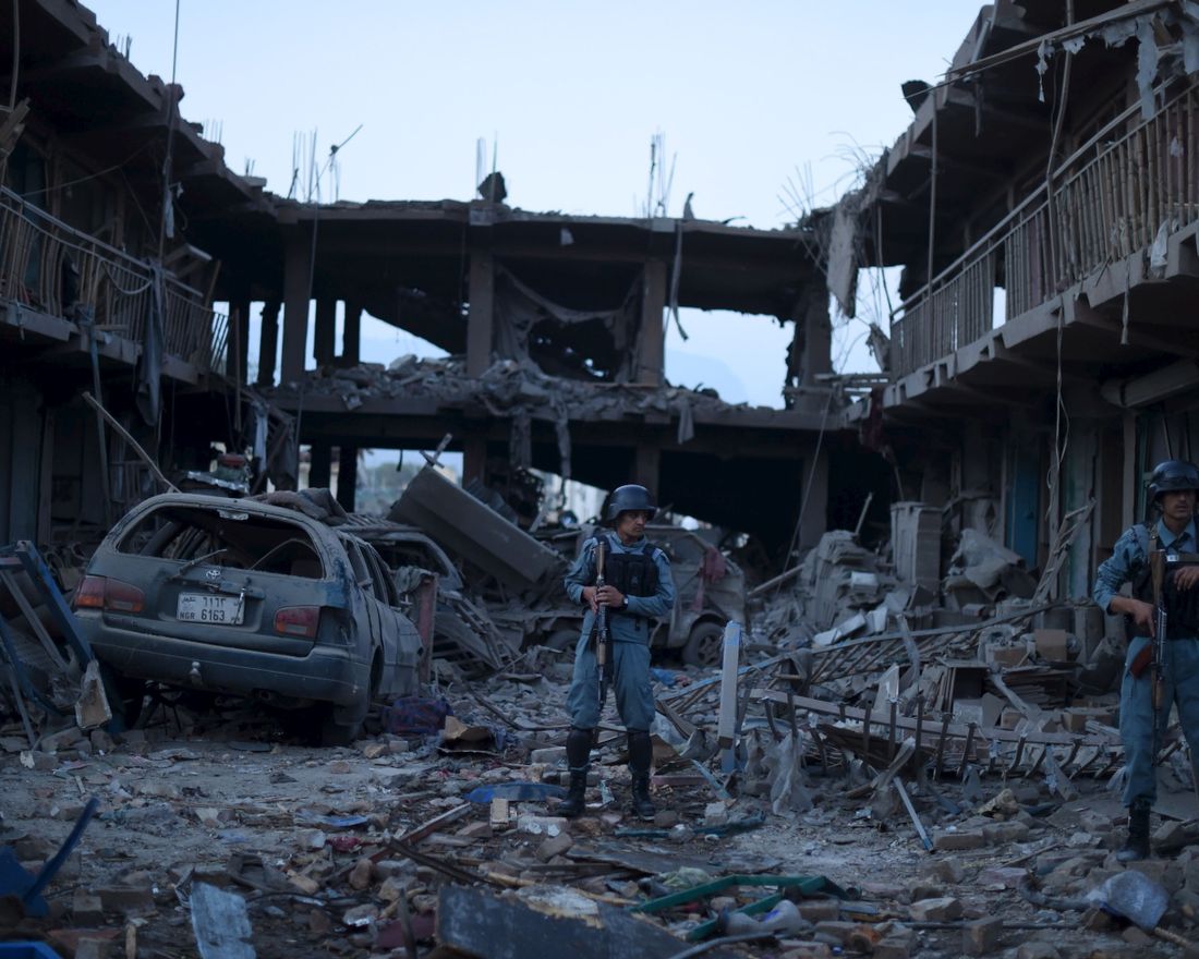(FILES) This file photo taken on August 7, 2015 shows Afghan policemen standing guard at a market destroyed by a powerful truck bomb in Kabul, the first major attack in the Afghan capital since the announcement of Taliban leader Mullah Omar's death. 
 War crimes prosecutors said on November 3, 2017 they will ask the International Criminal Court's judges for permission to launch a full-blown probe into crimes committed in war-torn Afghanistan. During a lengthy probe first made public in 2007, the ICC has been looking at possible war crimes dating back to 2003 by the Taliban, Afghan government forces and international forces including US troops. 
 / AFP PHOTO / SHAH MARAI