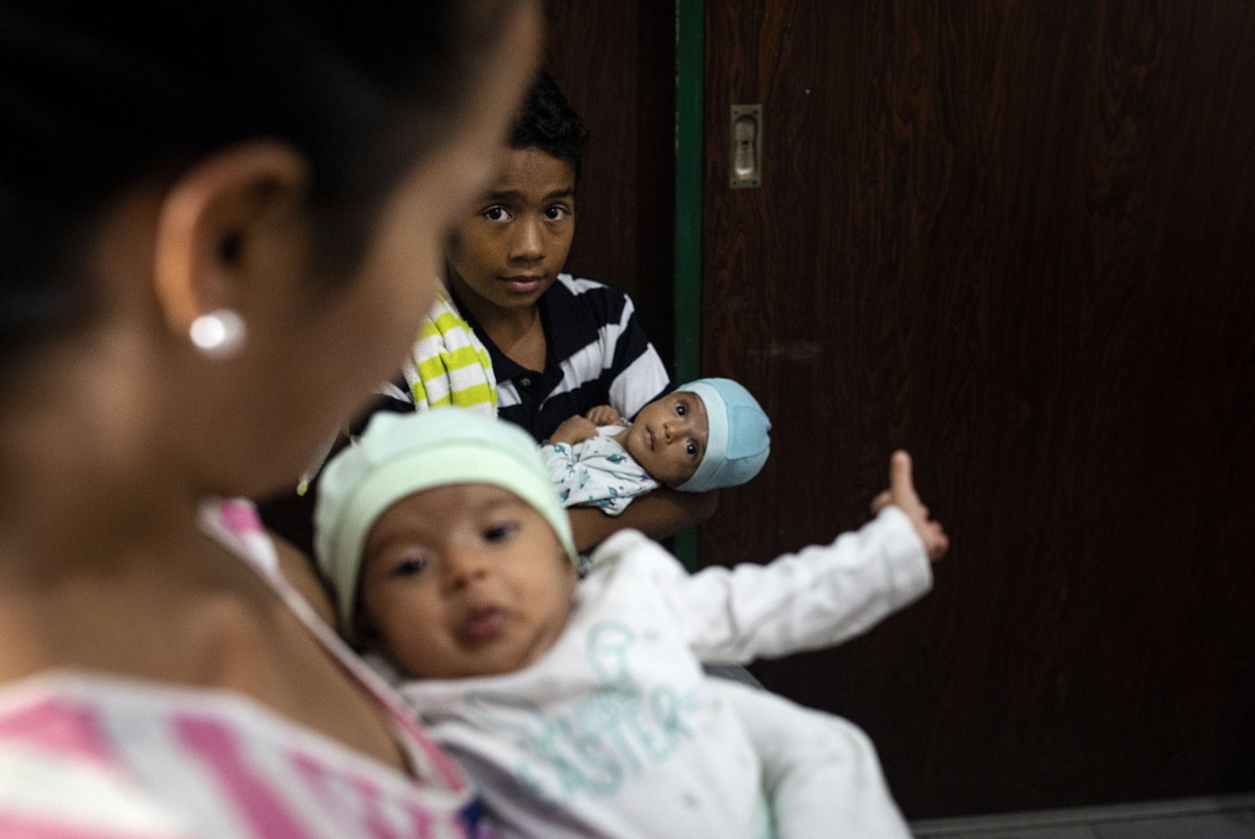 Caracas, Venezuela, 03.05.2019. Nancy har med seg tvilliingene Ashley og Aron, og får hjelp av sin eldre sønn, Carlos. Den humanitære situasjonen i Venezuela er kraftig forverret som følge av mangel på basisvarer samt skyhøye priser som følge av hyperiinflasjonen. Foto: Christopher Olssøn.