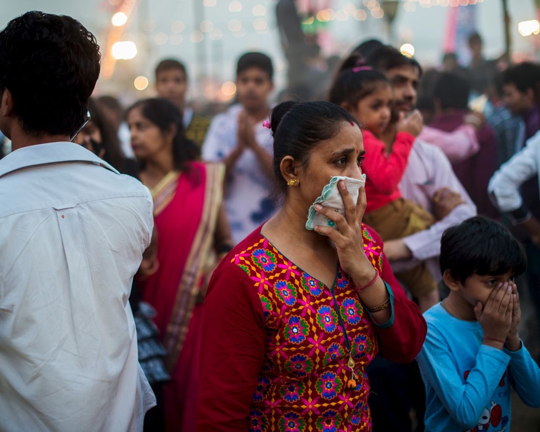 To go with Climate-warming-UN-COP21-India,FOCUS by Trudy Harris 
 In this October 22, 2015 photo, an Indian woman and a child cover their faces in an effort not to breath the fumes from fireworks and heavy dust while walking in a crowd at a local fair in New Delhi.  India's capital, with 18 million residents, has the world's most polluted air with six times the amount of small particulate matter (pm2.5) than what is considered safe, according to the World Health Organization (WHO). The air's hazardous amount of pm2.5 can reach deep into the lungs and enter the blood, causing serious long term health effect, with the WHO warning India has the world's highest death rate from chronic respiratory diseases. India, home to 13 of the world's top 20 polluted cities, is also the third largest emitter of greenhouse gases behind the United States and China. In Delhi, the air pollution is due to vehicle traffic including cargo trucks running on low-grade diesel, individual fires that residents burn in winter, crop being burnt by farmers in neighboring states, and construction site dust. Burning coal in power plants is also major contributor that is expected to increase hugely in the coming decades to match electricity needs of the ever-growing city and its booming satellite towns. AFP PHOTO / ROBERTO SCHMIDT