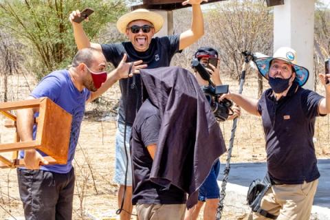 Grupo de filmagem posando ao ar livre.