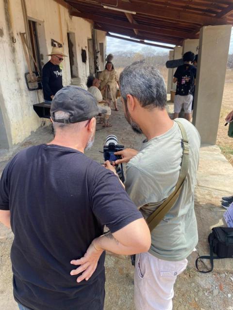 Equipe de filmagem ajustando câmera ao ar livre.