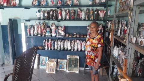 Mulher em loja de imagens religiosas e estátuas.