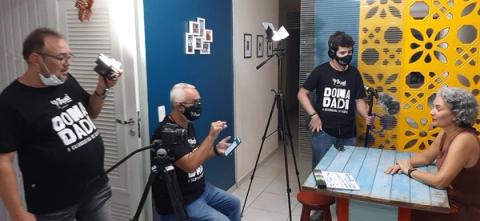 Filmagem interna com mulher sendo entrevistada e equipe operando câmeras.