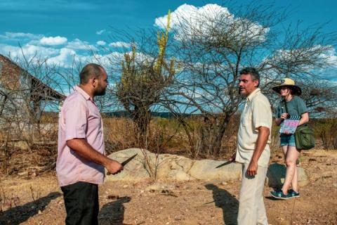 Dois homens segurando faca, mulher com claquete.