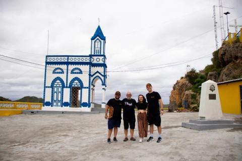 Equipe posando na frente de santuário azul e branco.