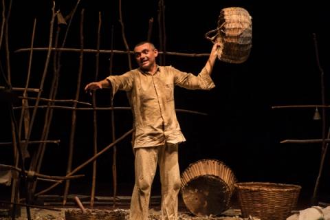 Ator segurando cesto de vime.
