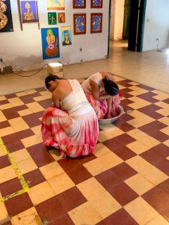 Duas bailarinas dançando em sala com vestidos branco e vermelho.