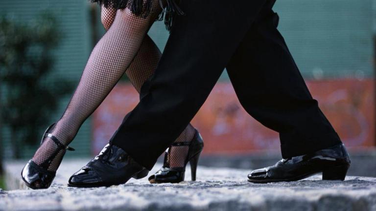 Pernas de casal dançando, com sapatos elegantes.