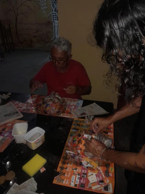 Participantes da Oficina de Artesanato em Papel para Adultos e Idosos juntos em uma mesa fazendo arte em papel.