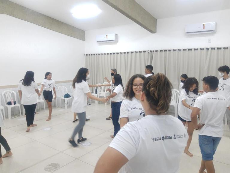 Grupo de pessoas em sala dançando forró.