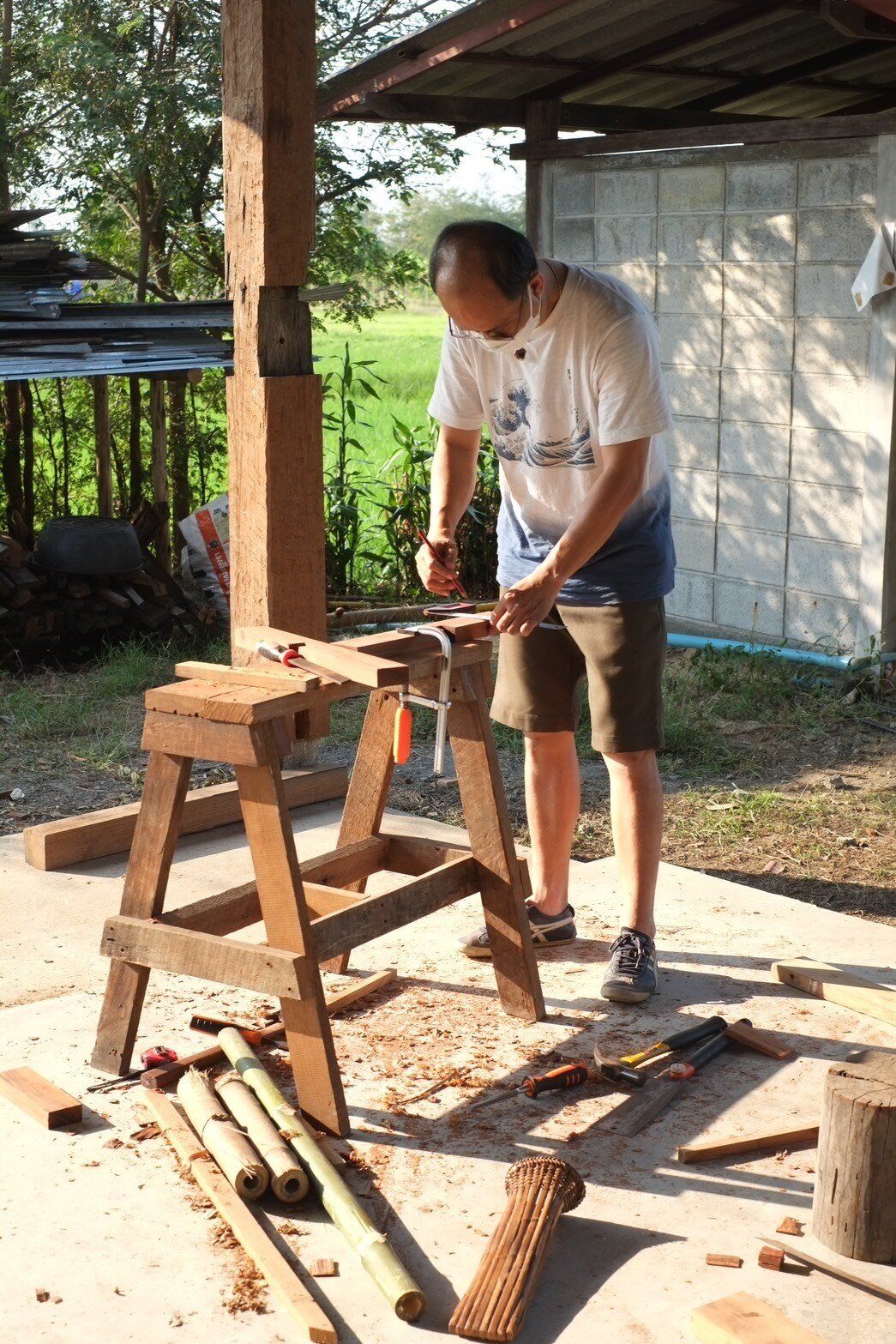 A participant measuring and marking timber at a workbench