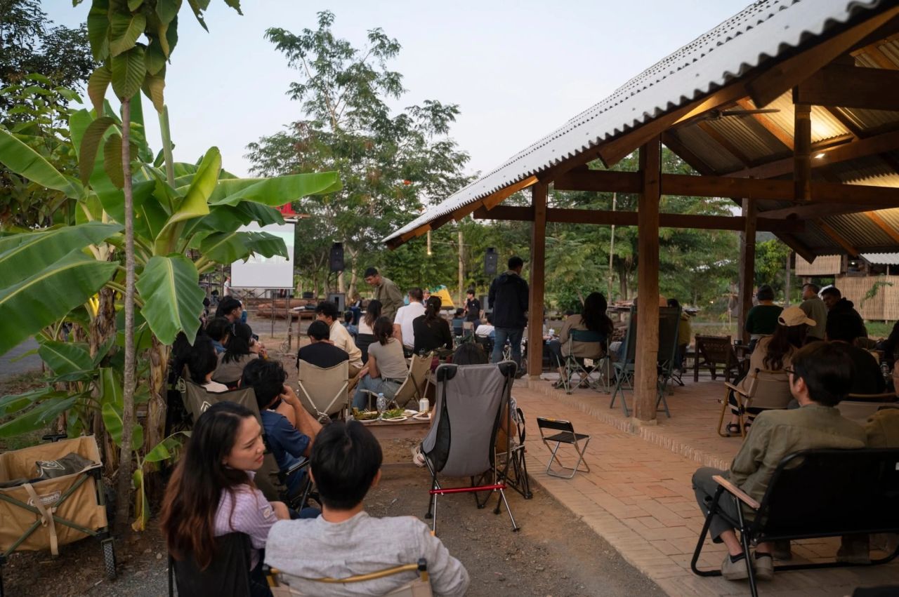 Audience members listening to an outdoor talk at Pham