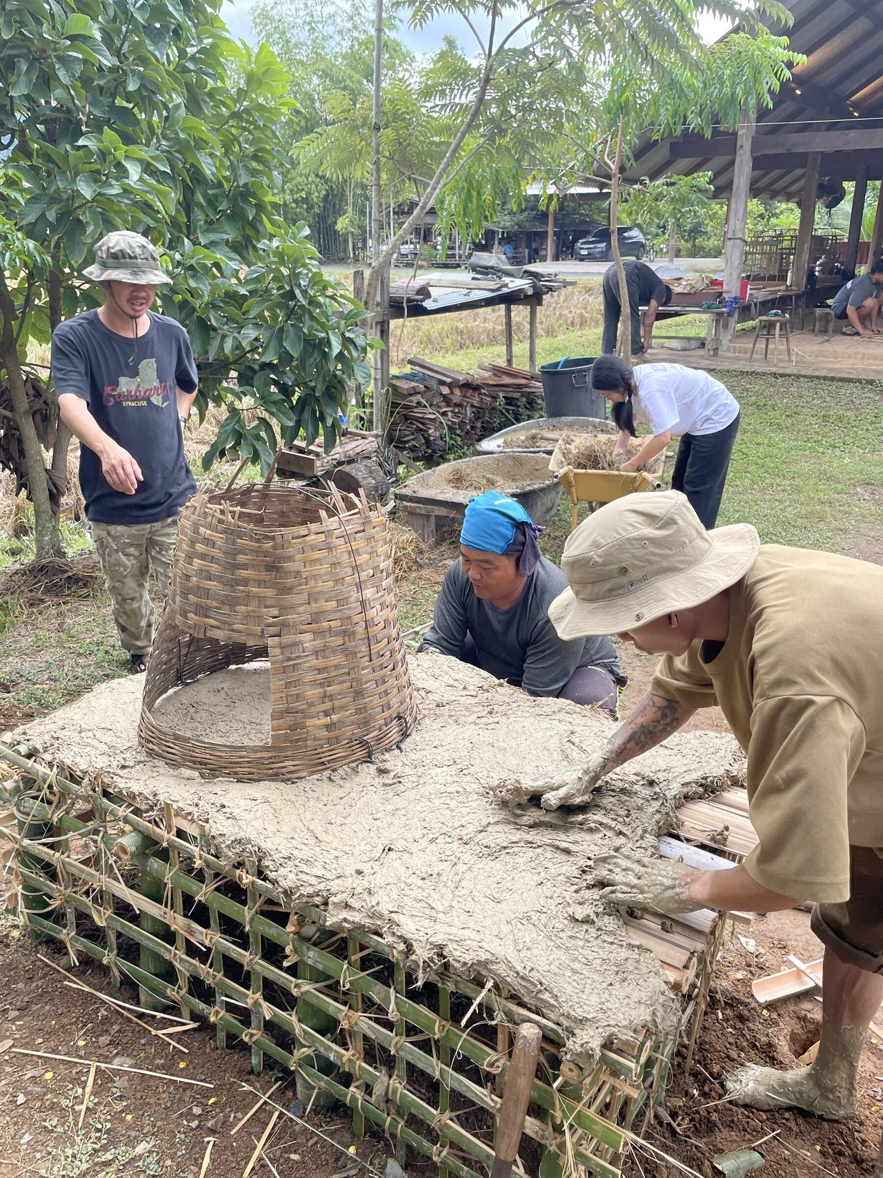 Participants shaping an earthen structure together
