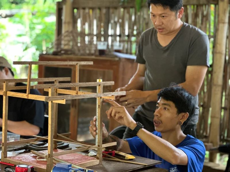 Two participants assembling the joints of a timber building model