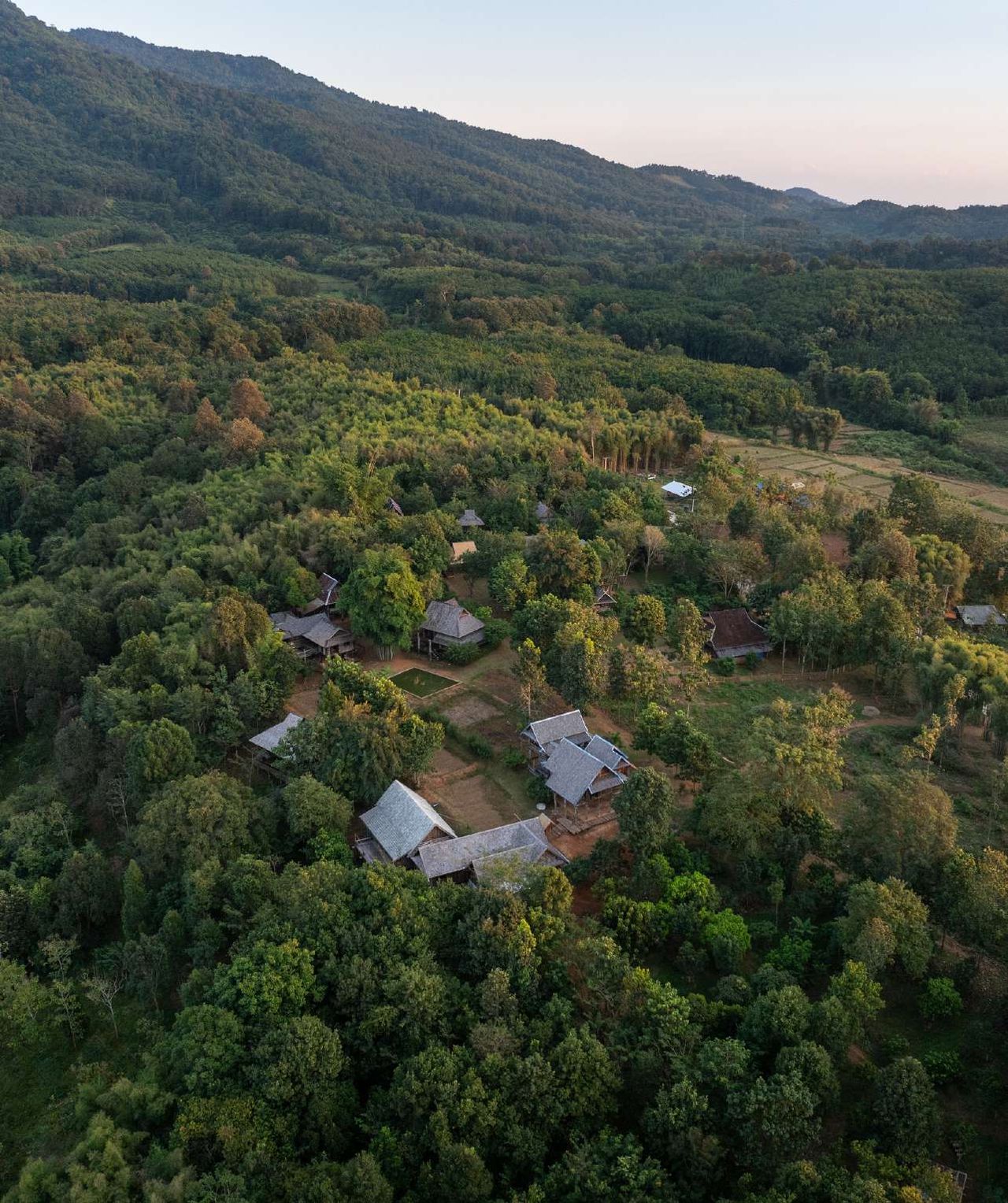 Aerial view of village houses among forested hills