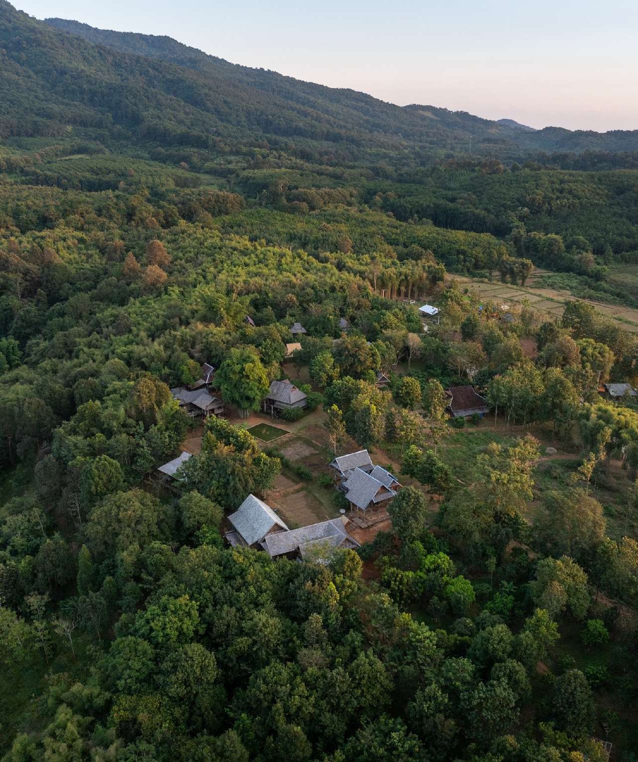 Aerial view of village houses among forested hills