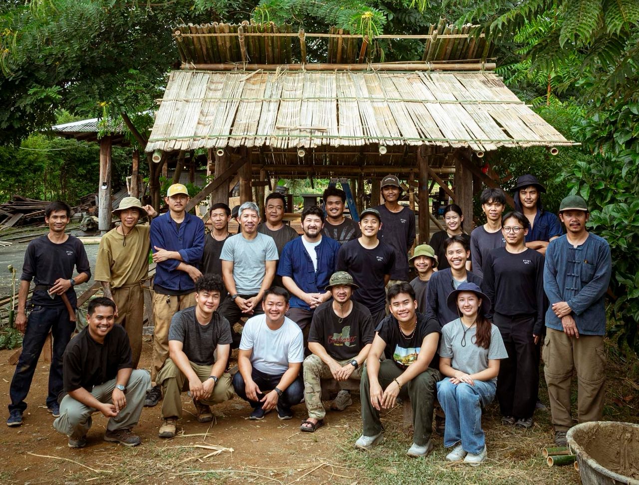 The Yangnar Studio team gathered in front of a timber and bamboo pavilion