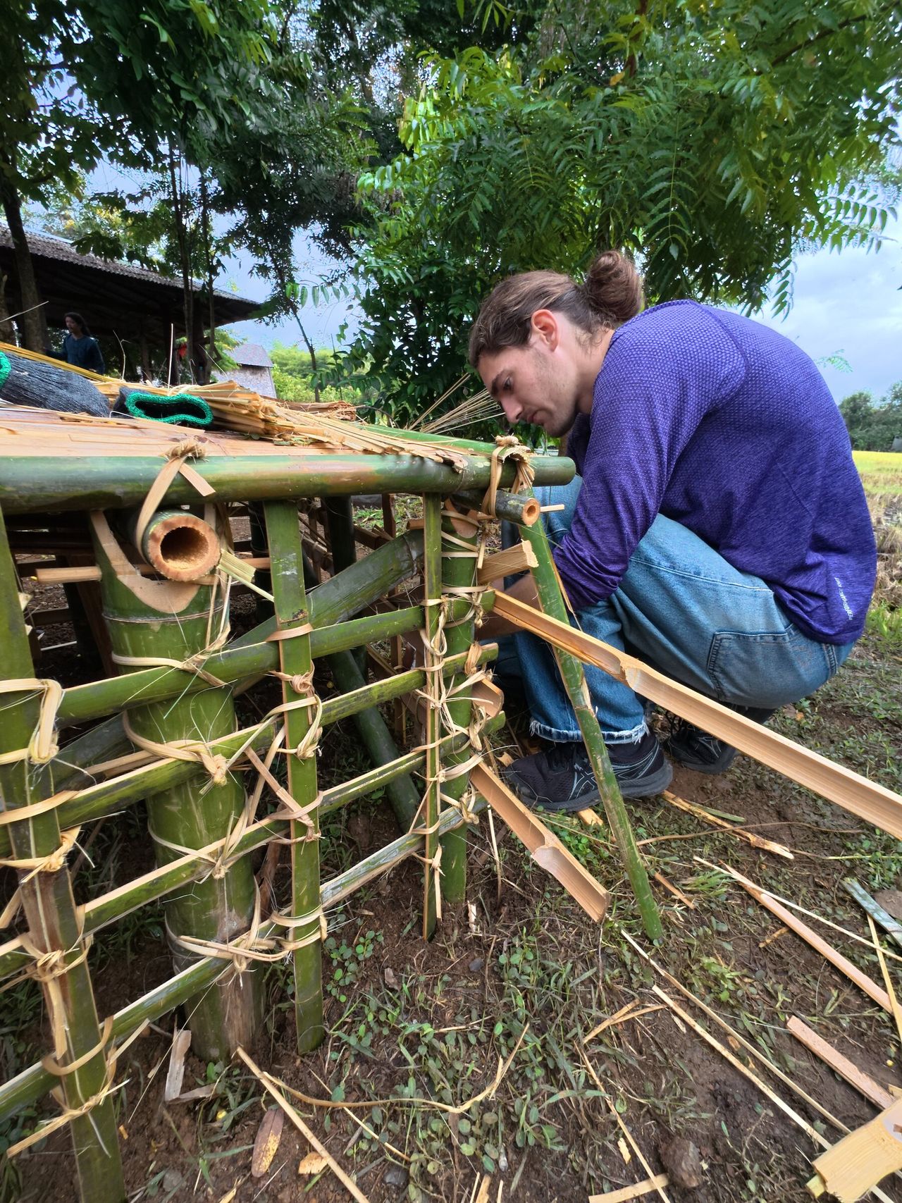 A participant tying bamboo pieces together by hand