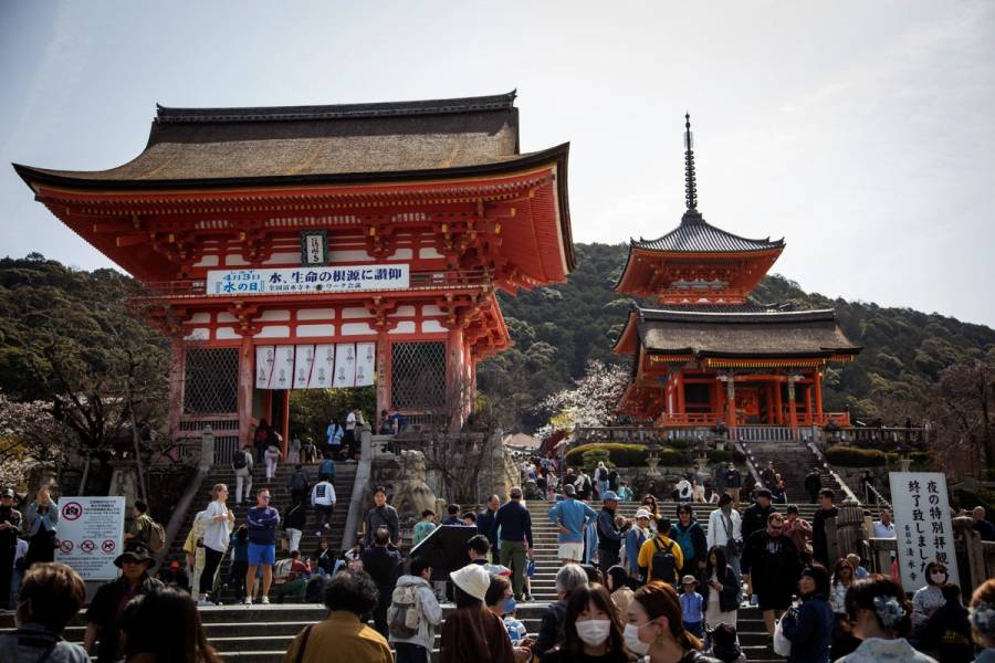 Kiyomizu-dera entrance gate and pagoda in eastern Kyoto, with large crowds of tourists on the steps below.