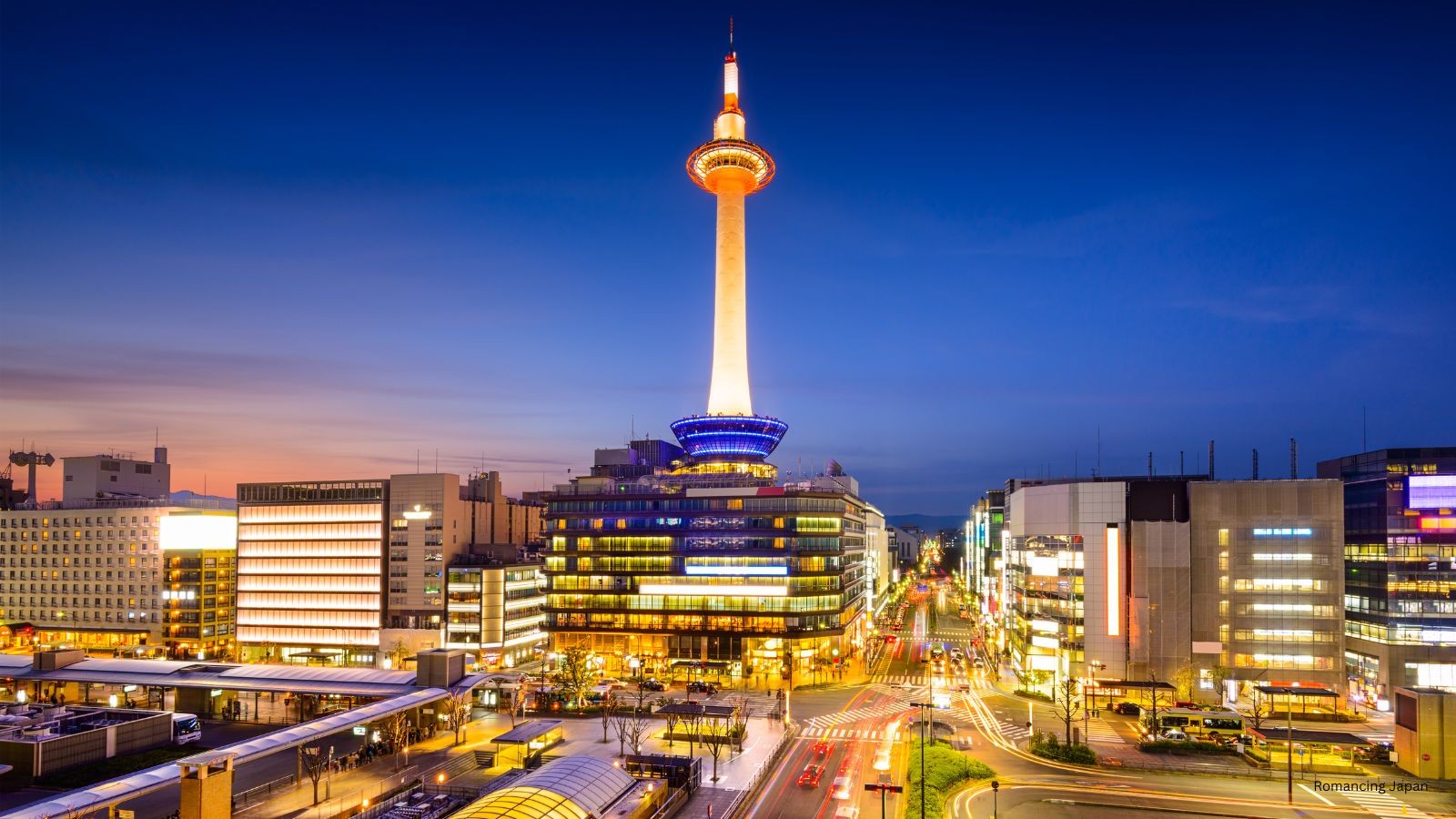 Kyoto Tower at twilight, above the Kyoto Station district. The rental shops most tourists start their day at are within a five-minute walk of this view. Most want their bikes back before this light fades.