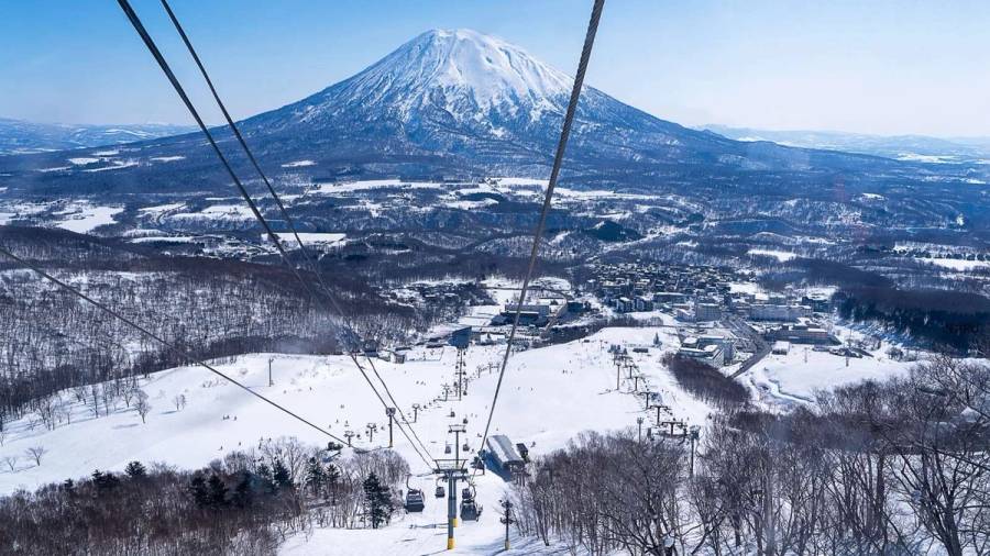 A ski lift in Niseko, Hokkaido, Japan, with mountains in the background.