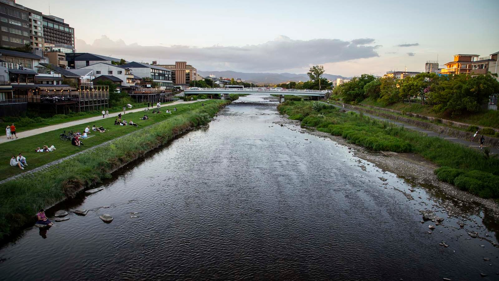 The Kamo River at dusk from Sanjo Bridge — the natural starting point for any ride along the bank. Locals sit here every evening like it's the most obvious thing in the world. It is.