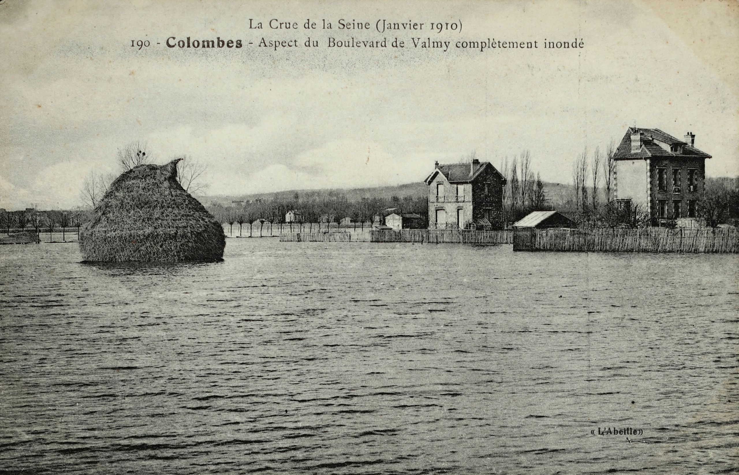 Carte postale ancienne montrant le boulevard de Valmy à Colombes inondé par la crue de la Seine en 1910, avec maisons isolées et champs submergés.