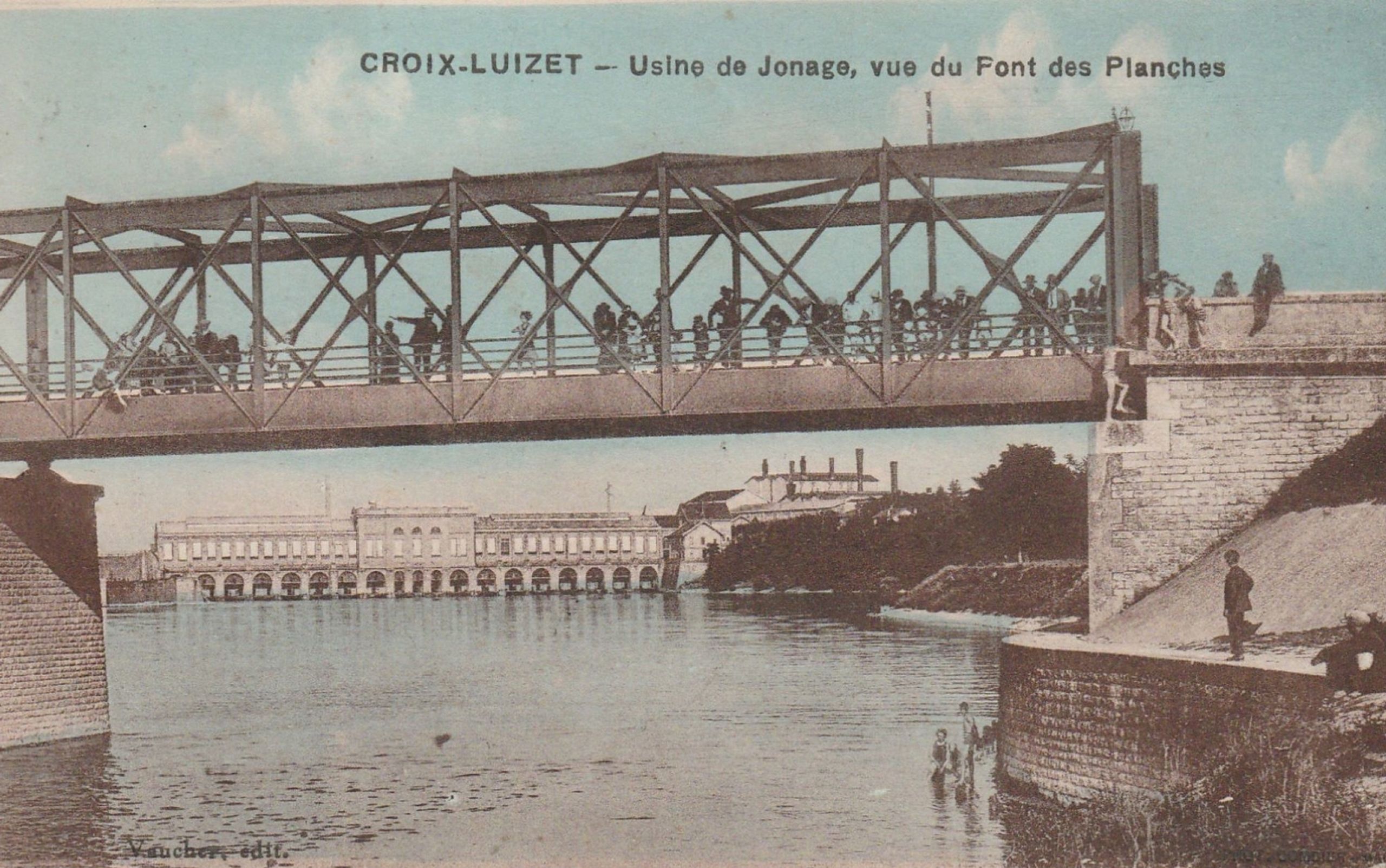 Vue ancienne du site industriel de Cusset à Villeurbanne : passerelle métallique treillis sur le canal, en arrière-plan la centrale hydroélectrique monumentale.
