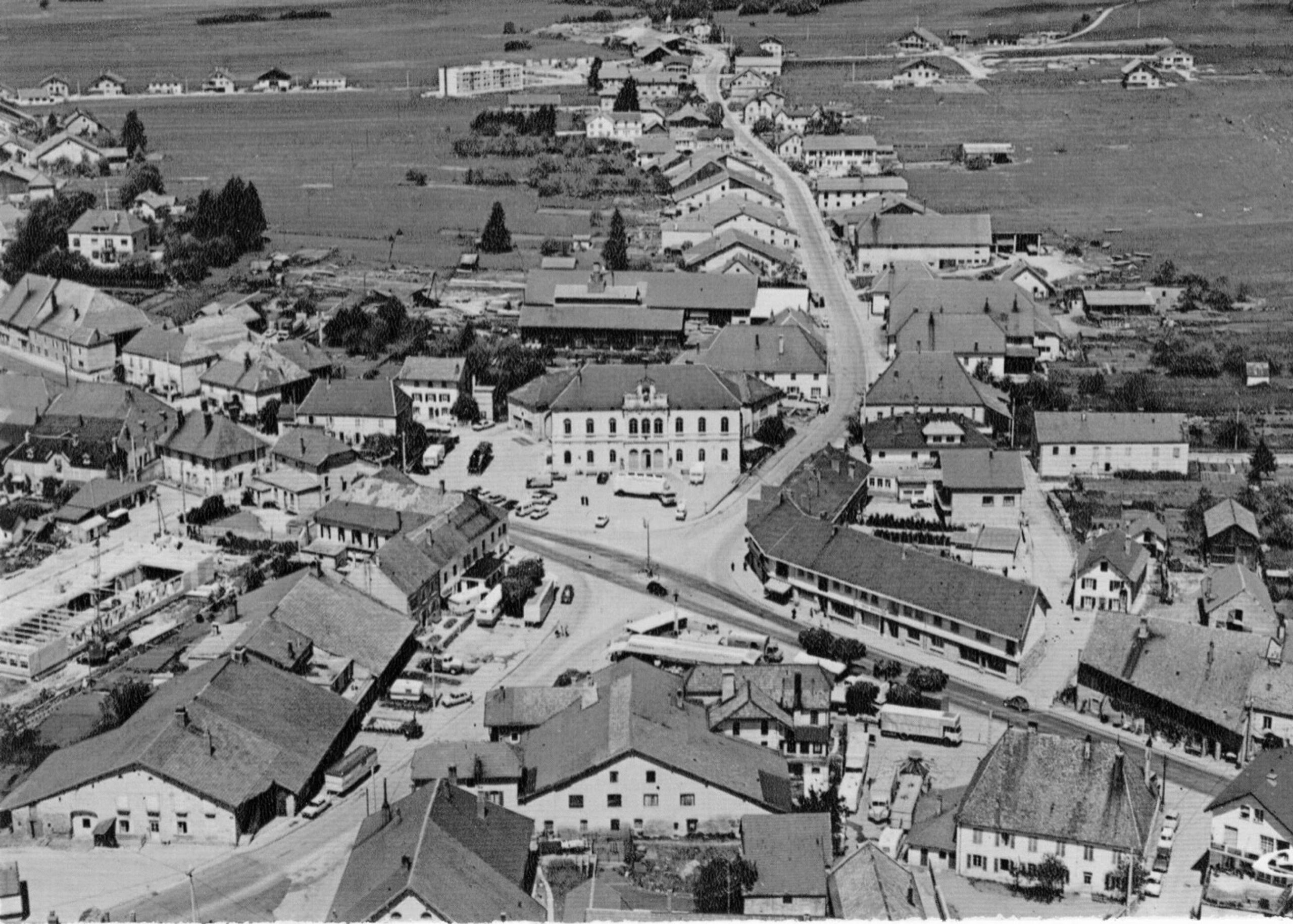 Vue aérienne historique du centre de Levier, montrant le tissu villageois dense et la parcelle centrale destinée au futur School complex Louis Pergaud.